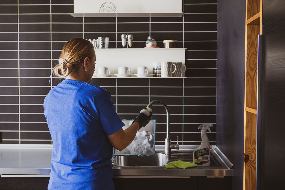 Pracownica CleanWhale w niebieskiej koszulce wykonuje sprzątanie mieszkań pod wynajem.